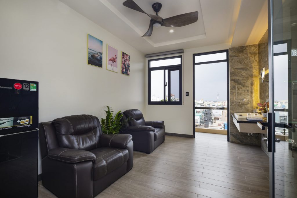 Đối diện phòng ngủ, phòng sinh hoạt được trang bị sofa và quạt trần MELODY để khách hàng thư giãn